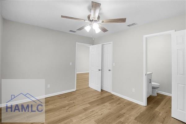 unfurnished bedroom featuring light wood-type flooring, ceiling fan, and ensuite bath