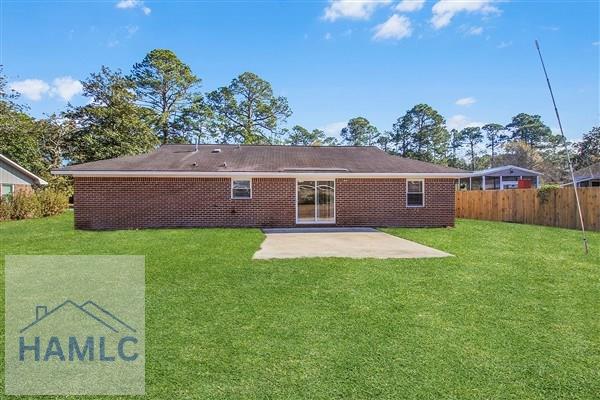 back of property featuring a patio area and a yard