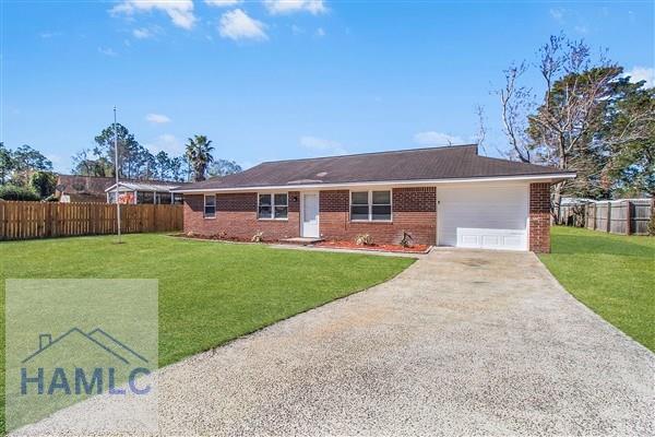 ranch-style home featuring a garage and a front lawn