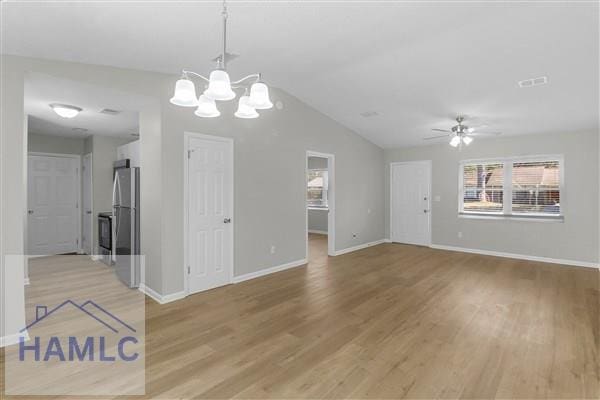 interior space with ceiling fan with notable chandelier, light hardwood / wood-style flooring, and vaulted ceiling