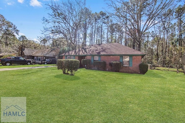 ranch-style house featuring brick siding and a front yard