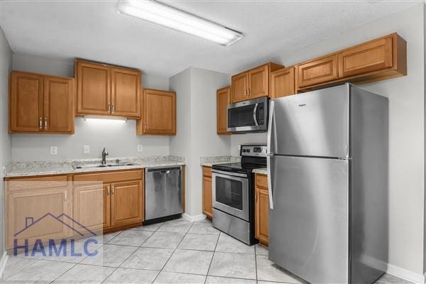 1110 Ricade Dr, Hinesville, GA 31313 - kitchen featuring brown cabinets, appliances with stainless steel finishes, a sink, and baseboards