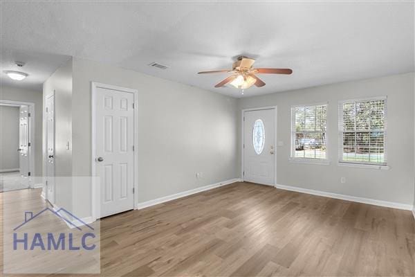1110 Ricade Dr, Hinesville, GA 31313 - foyer entrance with wood finished floors, baseboards, a ceiling fan, and visible vents