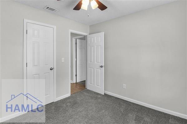 1110 Ricade Dr, Hinesville, GA 31313 - unfurnished bedroom featuring ceiling fan, visible vents, baseboards, and carpet floors