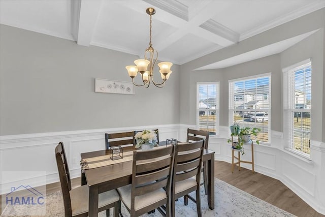 dining room with wood-type flooring, a notable chandelier, crown molding, and beamed ceiling