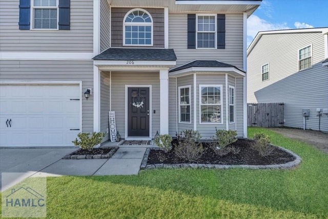 view of exterior entry featuring a lawn and a garage