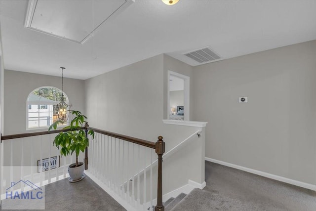 hall featuring a notable chandelier and carpet flooring