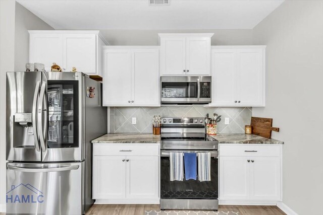 kitchen featuring stainless steel appliances and white cabinetry