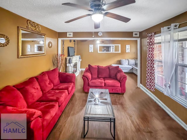 living room featuring a textured ceiling, ceiling fan, and wood-type flooring