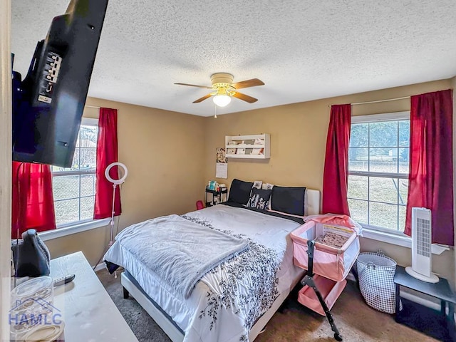 bedroom featuring ceiling fan, multiple windows, and a textured ceiling