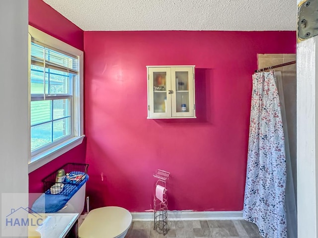 bathroom with toilet, a textured ceiling, walk in shower, and vanity