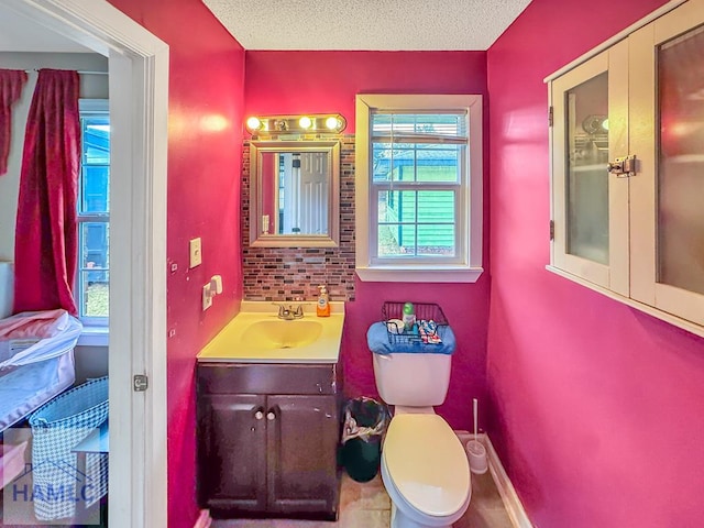 bathroom with a textured ceiling, toilet, and vanity