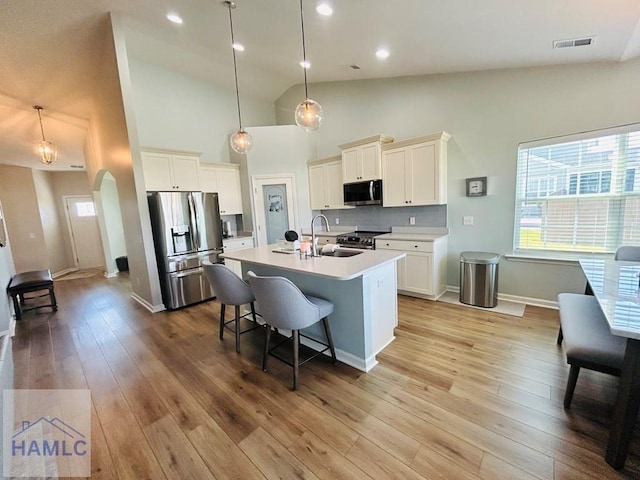 173 Akins Ranch Rd NE, Ludowici, GA 31316 - kitchen with stainless steel appliances, arched walkways, an island with sink, a breakfast bar area, and pendant lighting