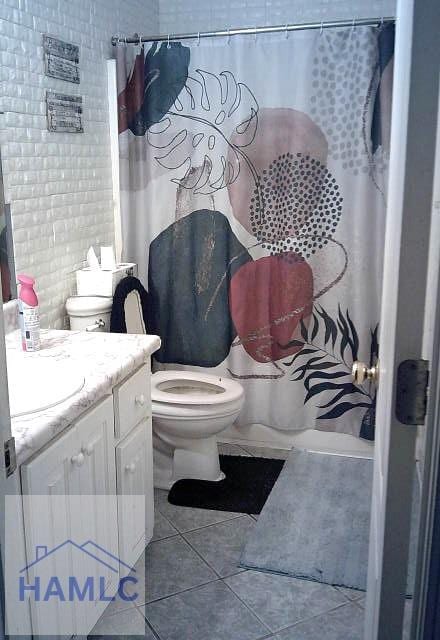 1013 Barley Dr, Hinesville, GA 31313 - bathroom featuring toilet, a shower with shower curtain, tile patterned flooring, and vanity