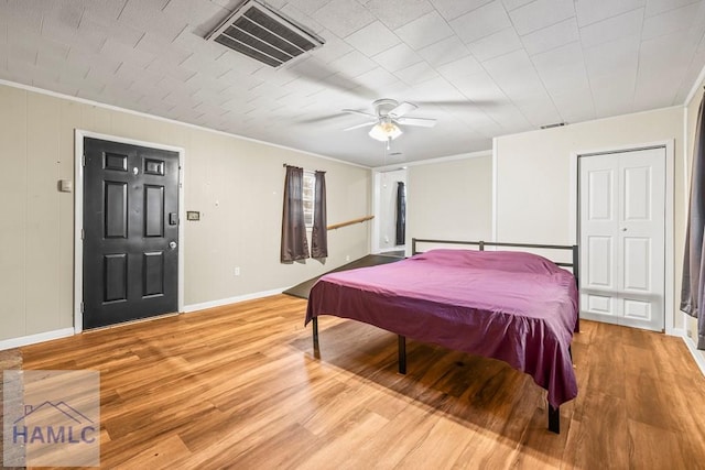 bedroom with ceiling fan, ornamental molding, and light wood-type flooring