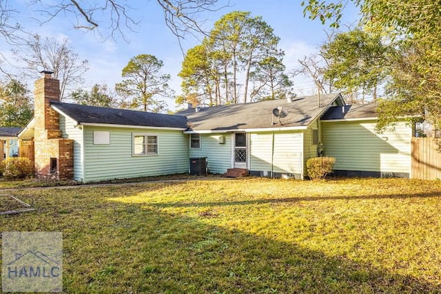 back of property with a yard and central air condition unit