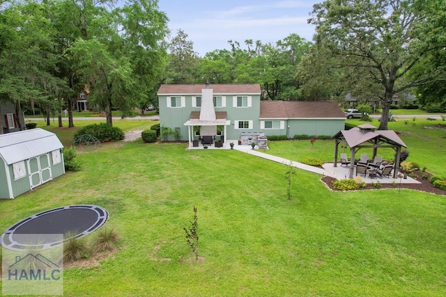 226 Topi Trl, Hinesville, GA 31313 - back of house featuring a trampoline, a gazebo, and a lawn