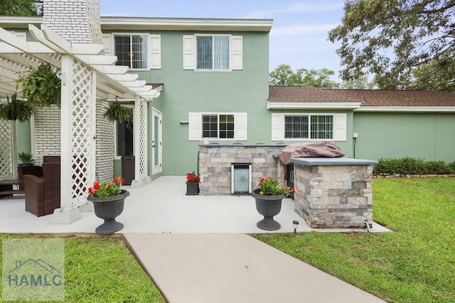 226 Topi Trl, Hinesville, GA 31313 - view of front facade with a pergola, stucco siding, a patio area, and a front yard