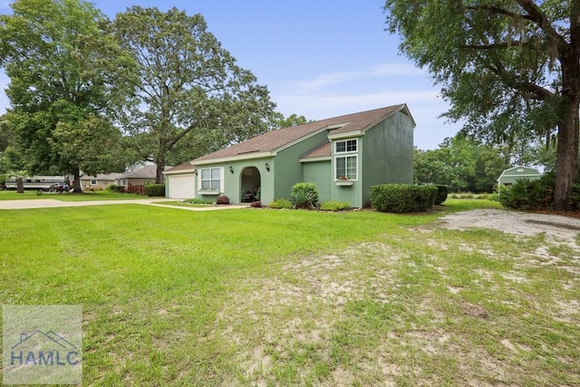 226 Topi Trl, Hinesville, GA 31313 - view of front of property with an attached garage, stucco siding, a front lawn, and driveway