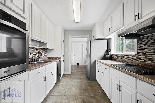 226 Topi Trl, Hinesville, GA 31313 - kitchen with appliances with stainless steel finishes, under cabinet range hood, a sink, tasteful backsplash, and white cabinets