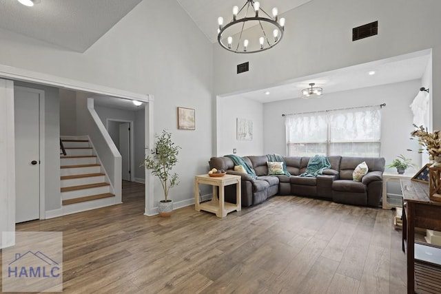 226 Topi Trl, Hinesville, GA 31313 - living room featuring a chandelier, wood finished floors, stairs, high vaulted ceiling, and baseboards