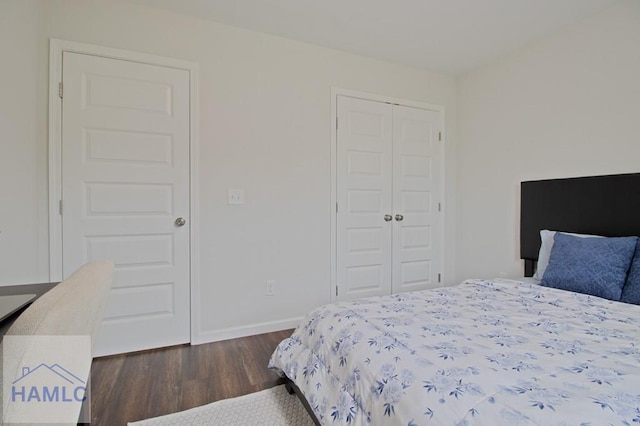 bedroom featuring a closet, baseboards, and dark wood finished floors