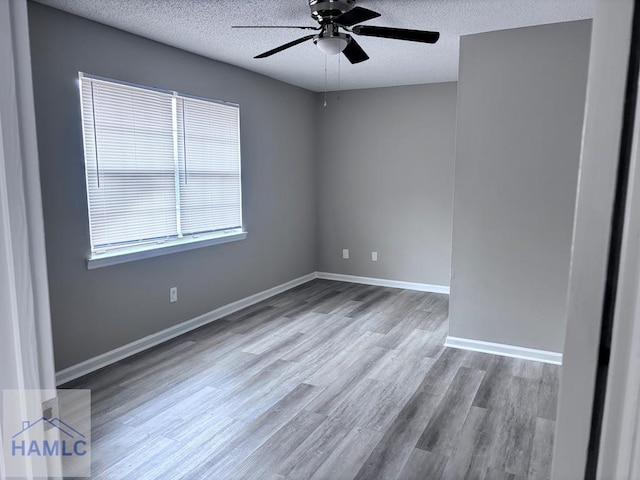 spare room with ceiling fan, light hardwood / wood-style flooring, and a textured ceiling