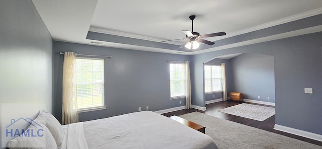 14 Cantebury Rd, Ludowici, GA 31316 - bedroom featuring arched walkways, crown molding, a tray ceiling, dark wood-style floors, and a ceiling fan