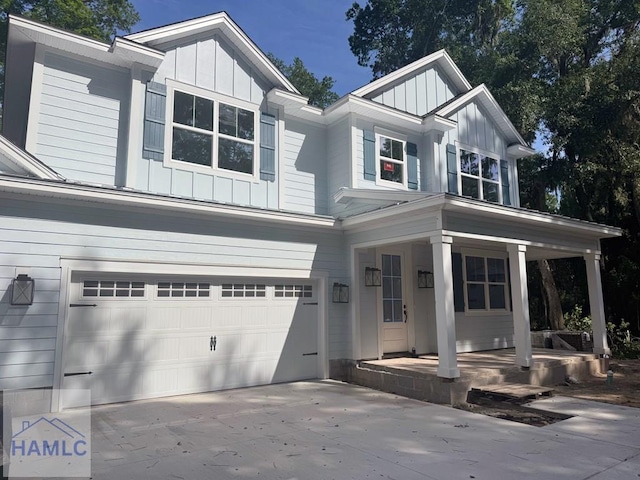 43 Belle Island Way, Richmond Hill, GA 31324 - view of front of house with board and batten siding, a porch, a garage, and concrete driveway