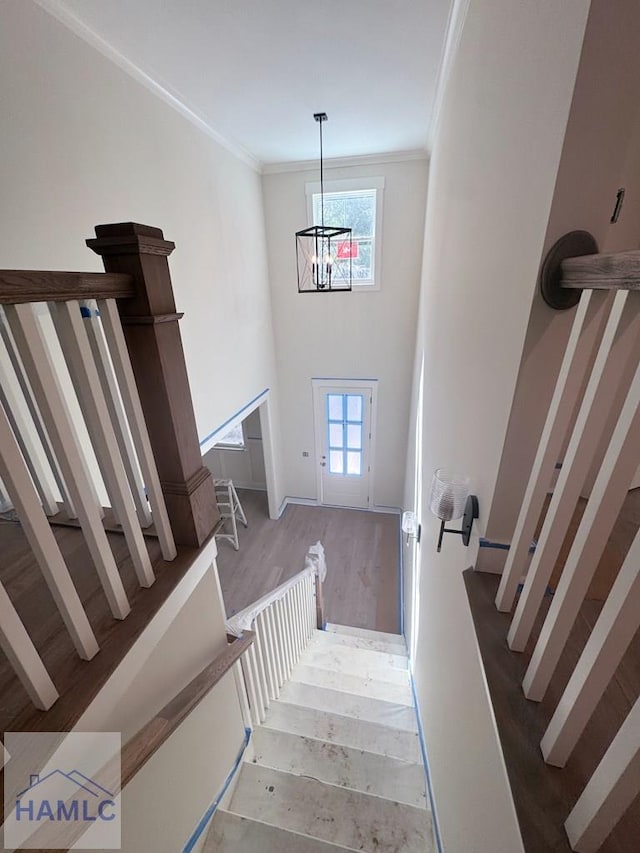 43 Belle Island Way, Richmond Hill, GA 31324 - stairs with a chandelier, healthy amount of natural light, ornamental molding, a high ceiling, and wood finished floors