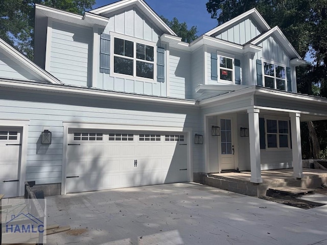 43 Belle Island Way, Richmond Hill, GA 31324 - view of front of house with board and batten siding, a porch, an attached garage, and driveway