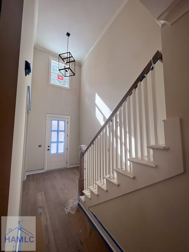 43 Belle Island Way, Richmond Hill, GA 31324 - foyer featuring a high ceiling, wood finished floors, crown molding, stairway, and a chandelier