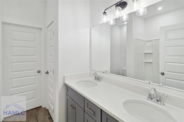 bathroom with hardwood / wood-style floors, vanity, and toilet