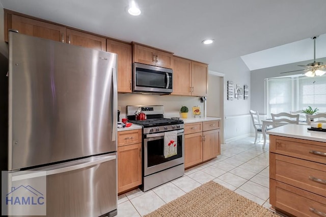 kitchen featuring appliances with stainless steel finishes, light tile patterned floors, ceiling fan, and lofted ceiling