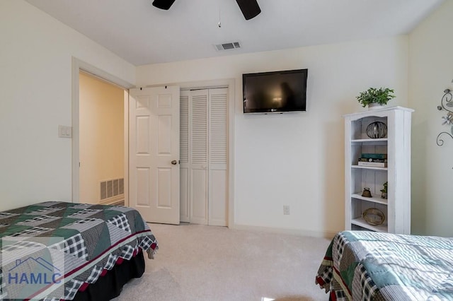 carpeted bedroom with ceiling fan and a closet