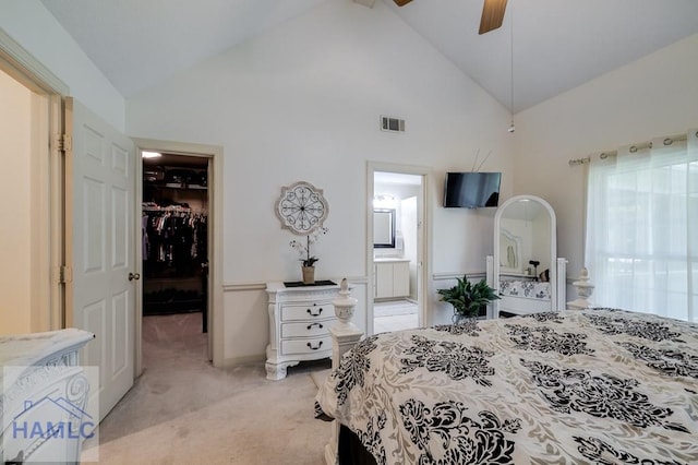 carpeted bedroom with ensuite bath, a spacious closet, ceiling fan, high vaulted ceiling, and a closet