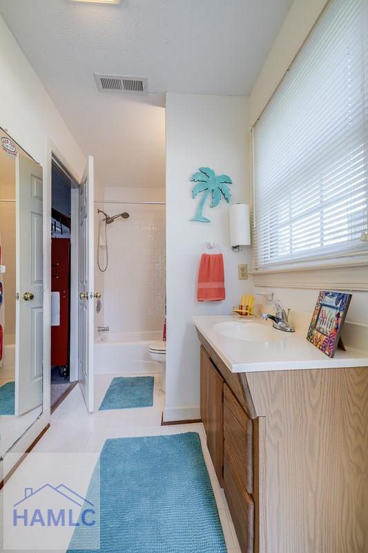 full bathroom with tile patterned flooring, vanity, toilet, and tub / shower combination