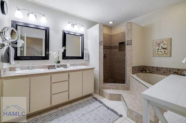 bathroom with tile patterned floors, vanity, a textured ceiling, and independent shower and bath