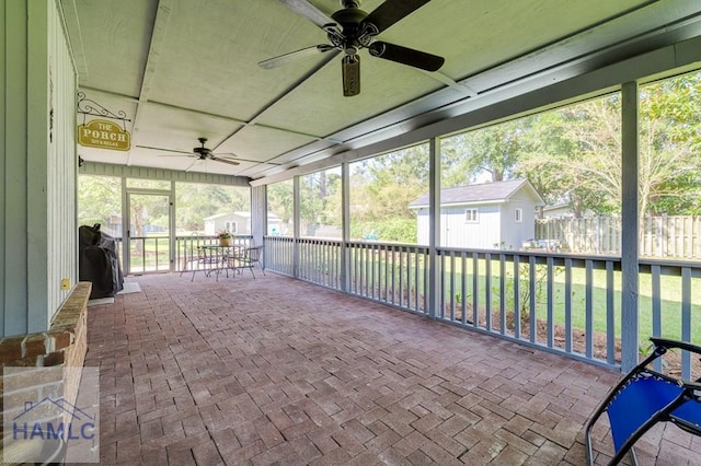 unfurnished sunroom with ceiling fan