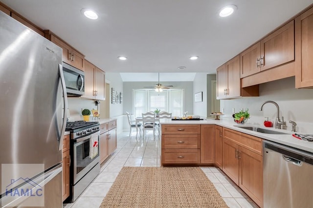 kitchen featuring kitchen peninsula, sink, light tile patterned flooring, and appliances with stainless steel finishes