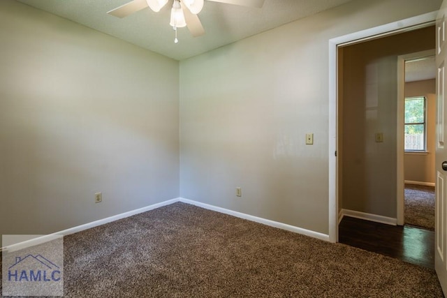 spare room featuring ceiling fan and dark carpet