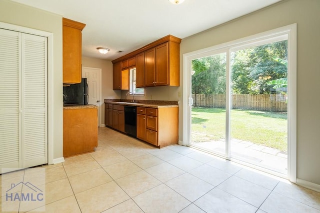 kitchen with decorative backsplash, sink, light tile patterned flooring, and black appliances