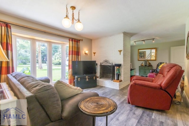375 Eastridge Rd, Savannah, GA 31406 - living room featuring hardwood / wood-style floors, a chandelier, a fireplace, and track lighting