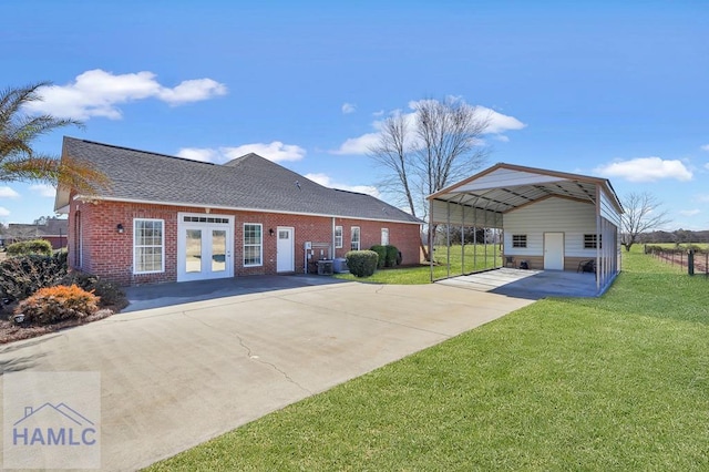 back of house featuring a lawn, a carport, and french doors