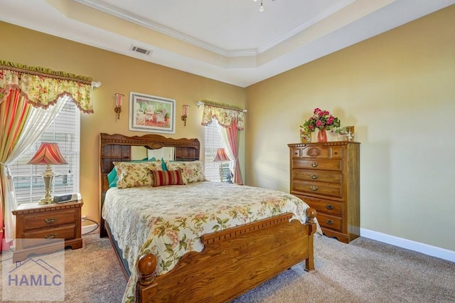 bedroom with a raised ceiling, crown molding, and light colored carpet