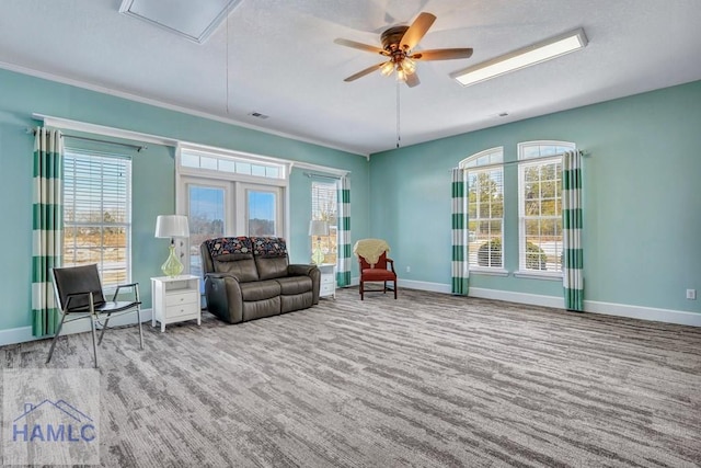 carpeted living room featuring crown molding and ceiling fan