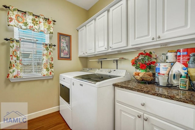 clothes washing area featuring dark hardwood / wood-style flooring, cabinets, and washer and dryer