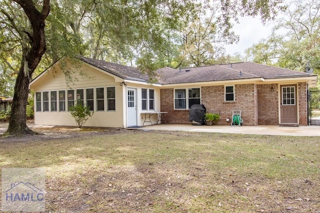 back of property featuring a patio and a lawn