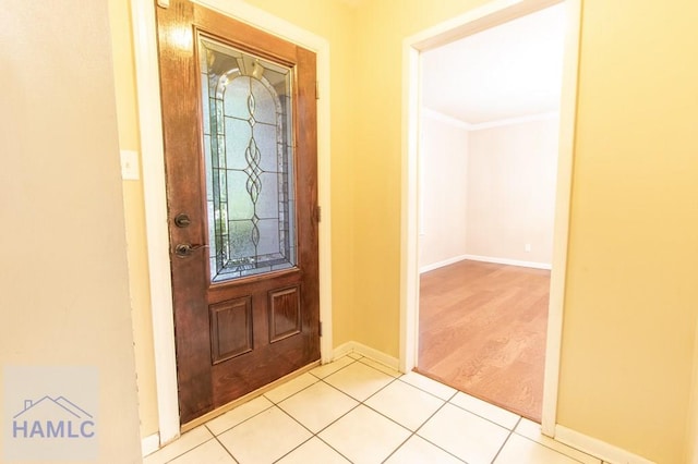 tiled foyer entrance featuring crown molding