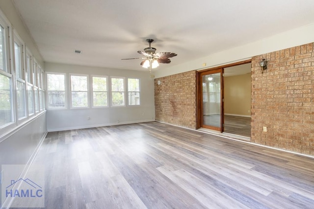 unfurnished sunroom featuring ceiling fan